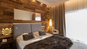 a bedroom with a large bed with a wooden wall at Sandra Spa Karpacz & Aquapark in Karpacz