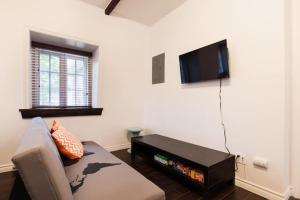 a living room with a couch and a flat screen tv at Comfort & Getaway in Old Levis - Studio Urbain in Lévis