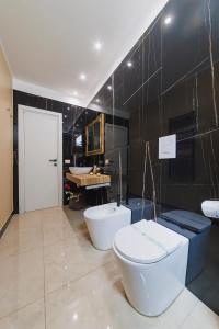 a bathroom with two sinks and a toilet and a tub at Ventidue Venti in Bari