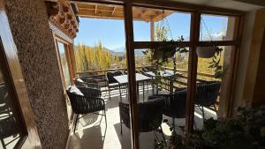 a patio with a table and chairs on a balcony at Overland Heights - Near Leh Airport in Leh