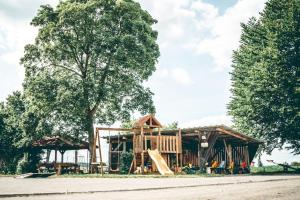 a log cabin with a slide and a playground at Ferienhof Mültner in Nordheim vor der Rhön