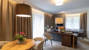 a living room with a table and chairs and a kitchen at Sandra Spa Karpacz & Aquapark in Karpacz