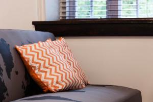 an orange and white pillow sitting on a couch at Comfort & Getaway in Old Levis - Studio Urbain in Lévis