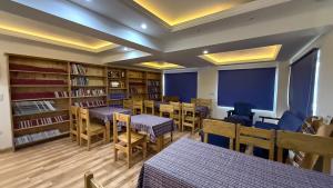 a library with tables and chairs and book shelves at Overland Heights - Near Leh Airport in Leh