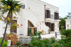 a white house with a palm tree in front of it at Casa Macchiosa in Torre Canne