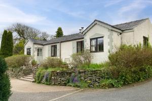 a white house with a stone wall at 1 Bed in Carmel oc-wai213 in Llanerchymedd