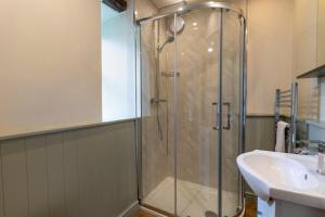 a bathroom with a glass shower and a sink at 1 Bed in Carmel oc-wai213 in Llanerchymedd +8 photos