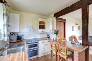 a kitchen with white cabinets and a wooden counter top at 1 Bed in Llanerchymedd oc-wai212 in Llanerchymedd +9 photos
