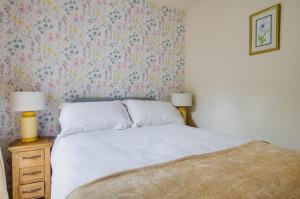 a bedroom with a bed with a floral wallpaper at 1 Bed in Llanerchymedd oc-wai212 in Llanerchymedd