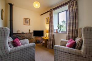 a living room with two chairs and a television at 1 Bed in Llanerchymedd oc-wai212 in Llanerchymedd