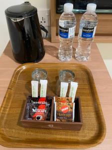a tray with snacks and water bottles on a counter at Blissful Homestay Batam in Nagoya