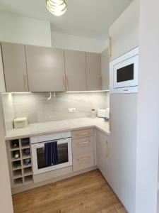 a kitchen with white appliances and a white refrigerator at Enidor Wellness Apartman in Siófok