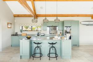 a kitchen with blue cabinets and bar stools at 3 Bed in Wendron oc-w29093 in Wendron