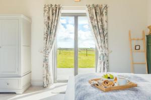 a white bedroom with a tray of fruit on a bed at 3 Bed in Wendron oc-w29093 in Wendron