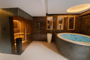 a bathroom with a large tub and a shower at Hotel Awam in Hradec Králové
