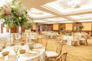 a banquet hall with white tables and chairs and flowers at Ona Mar Menor Golf & Spa in Torre-Pacheco +32 photos