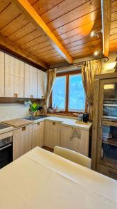 a kitchen with wooden ceilings and a table in a room at Duplex Esclusivo Bardonecchia - Centro - Garage in Bardonecchia
