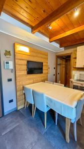 a dining room with a table and chairs and a tv at Duplex Esclusivo Bardonecchia - Centro - Garage in Bardonecchia