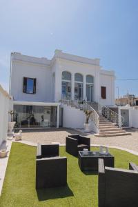 a large white house with black furniture and grass at Ventidue Venti in Bari