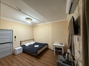 a small bedroom with a bed and a table at Delfin Hotel Restaurant Spa Ailevi in Ganja