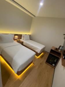 a hotel room with two beds and a table at Blissful Homestay Batam in Nagoya