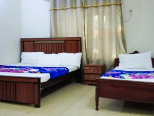 two beds in a room with two at Satti Palace Guest House in Rawalpindi