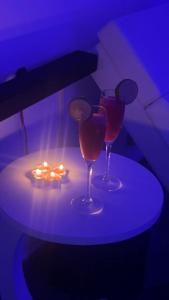 two wine glasses sitting on a table with a light at Suite Dima in Vedène