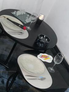 a black table with plates and wine glasses on it at Suite Dima in Vedène +7 photos