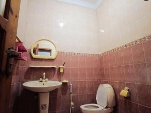 a bathroom with a sink and a toilet and a mirror at Satti Palace Guest House in Rawalpindi +39 photos