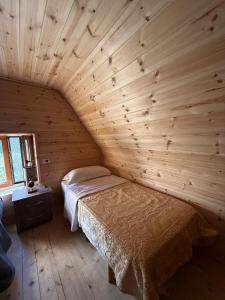 a bedroom with a bed in a wooden room at Oda Pisha Theth in Grumas +18 photos
