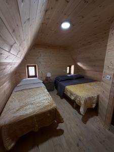 a bedroom with two beds in a wooden cabin at Oda Pisha Theth in Grumas