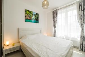 a bedroom with a white bed and a window at Modern Studio near Old Town in Braşov