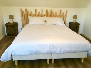 a bedroom with a large white bed with two lamps at Villa Myriam in Deauville