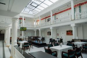 a restaurant with tables and chairs and a skylight at Kampoeng Indonesia Hotel in Khodzha-Ismail