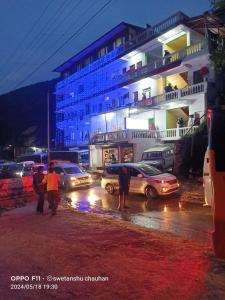 a group of people walking down a street with cars at Hotel Priyanshu in Madheso