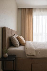 a bedroom with a bed with two pillows and a window at Simba Apartments Baile Felix in Baile Felix