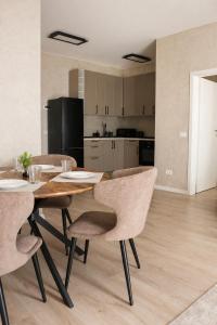 a kitchen and dining room with a wooden table and chairs at Simba Apartments Baile Felix in Baile Felix