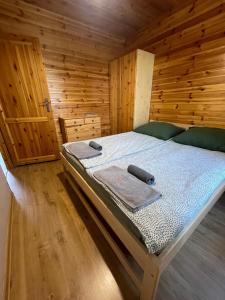 a bedroom with a bed in a wooden cabin at Domki całoroczne - u Ptaka - Miłków in Miłków