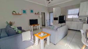a living room with a couch and a table at Utopia Guest House in Alberton
