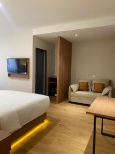 a hotel room with a bed and a couch at Blissful Homestay Batam in Nagoya