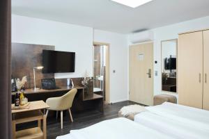 a hotel room with a bed and a desk with a desk at Altstadthotel Arte in Fulda