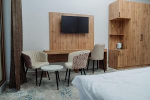 a hotel room with a table and chairs and a tv at Kampoeng Indonesia Hotel in Khodzha-Ismail +38 photos