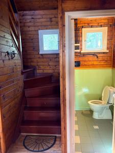 a bathroom with a toilet and stairs in a cabin at Chatičky pod Kamínkem Doksy in Doksy +22 photos