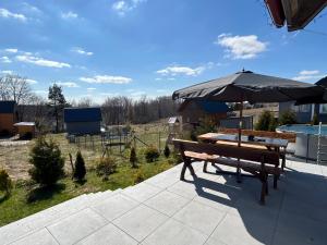 a picnic table and an umbrella on a patio at ''Kaszebe ''Domek letniskowy całoroczny z jacuzzi ,klimatyzacja nad jeziorem Raduńskim in Borzestowska Huta