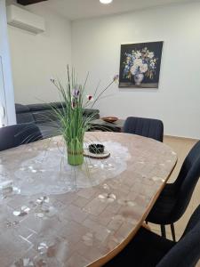 a dining room table with a vase of flowers on it at Guest house Lavanda 4 in Njivice +29 photos