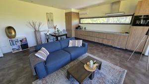 a living room with a blue couch and a table at Sfeervol chalet midden in de natuur in Halle
