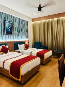 a hotel room with two beds and a window at Celestial International in Taliparamba