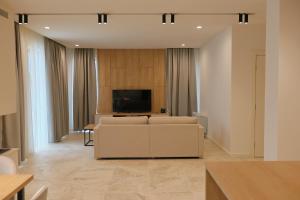 a living room with a couch and a flat screen tv at Complex SamElyon Residence in Samokov