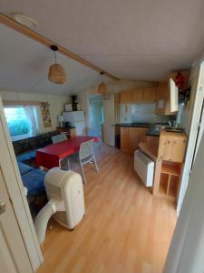 a kitchen and living room with a red table and chairs at mobile home A15 in Boofzheim +5 photos