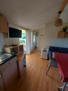 a kitchen and living room with a table and a couch at mobile home A15 in Boofzheim